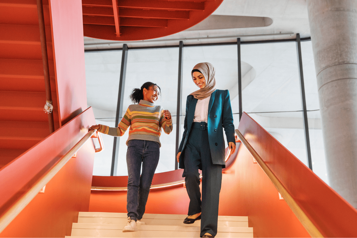 Two female students walking down the stairs together