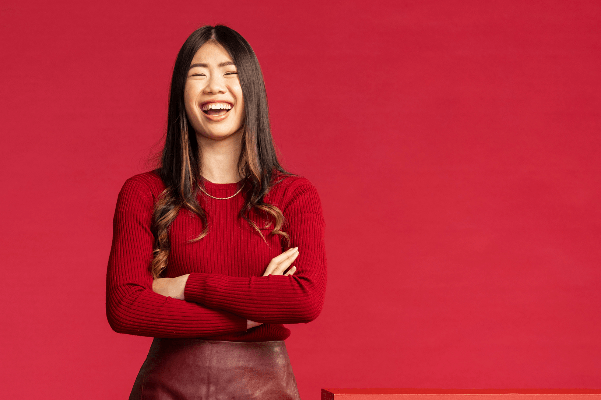 A female student standing in front of a crimson background