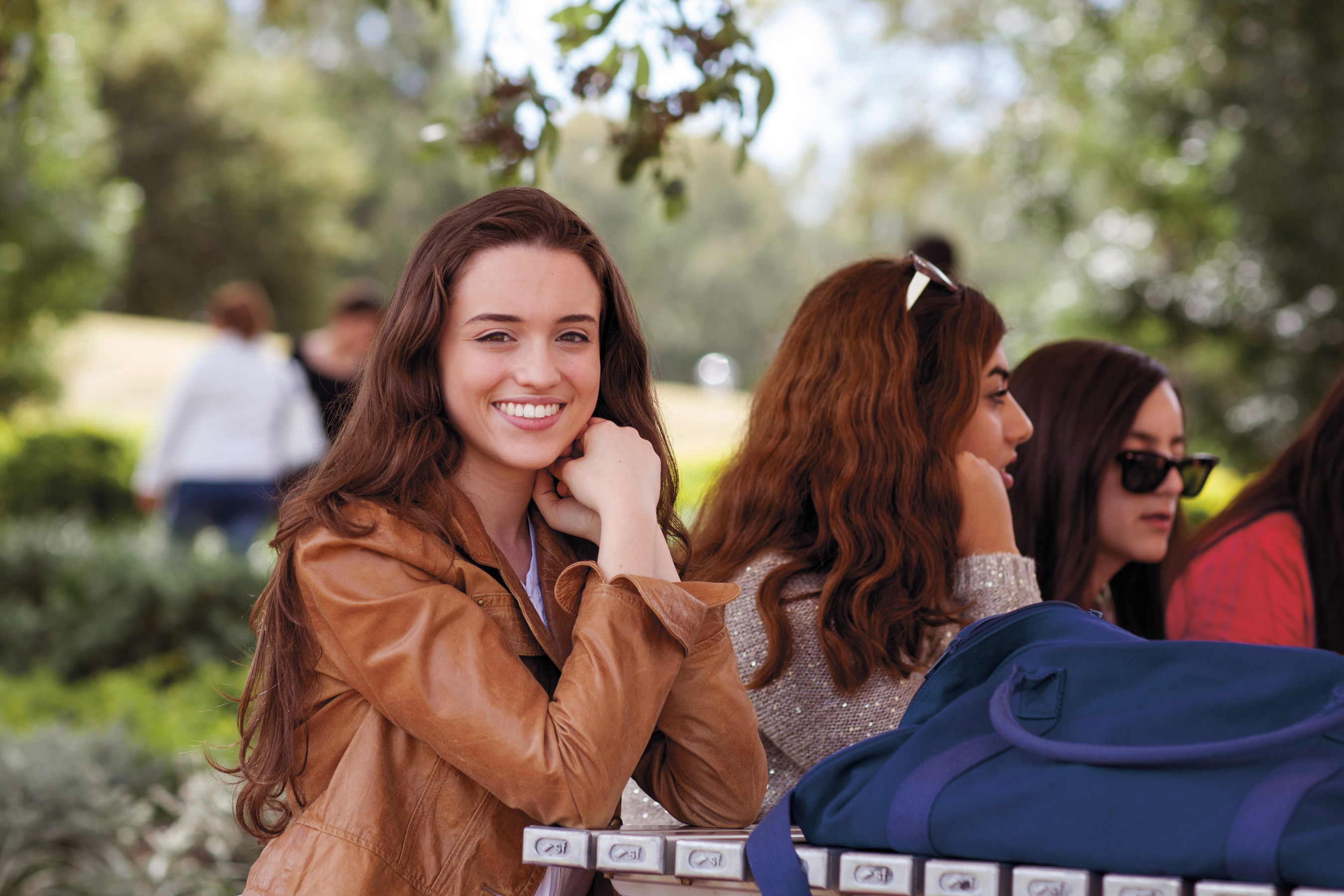 Western female student sitting with friends and smiling