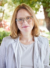 Shoulder-up image of Jessica Weir in a white shirt and necklace