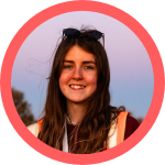 photo, head and shoulders of person smiling, sunglasses on head, long brown hair, looking directly at camera