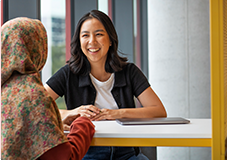 Two students sitting at table talking