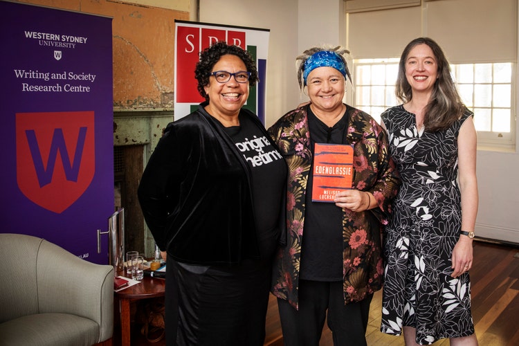 Sandra Phillips, Melissa Lucashenko and Kate Fagan are all standing in a row and smiling at the camera.